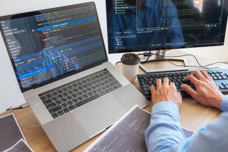 亚洲男子工作代码程序开发人员计算机网络开发工作设计软件在办公桌上
